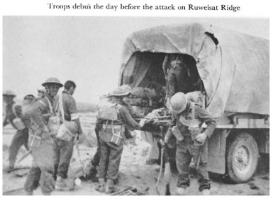 Black and white photograph of troops with a truck